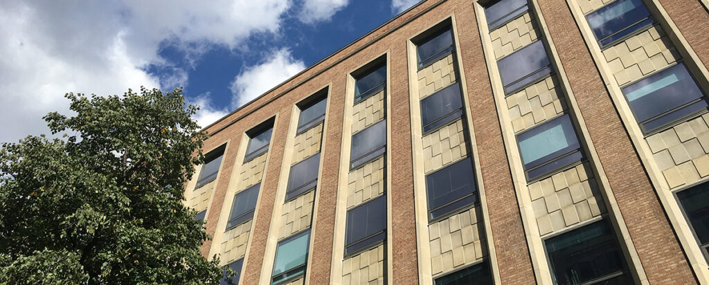 Looking up at FIFSW's building and into a blue sky with clouds.